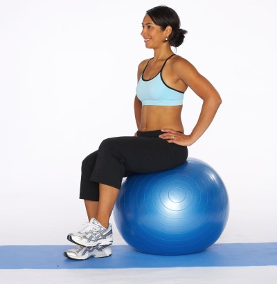 Woman using an exercise ball to prevent lower back pain.