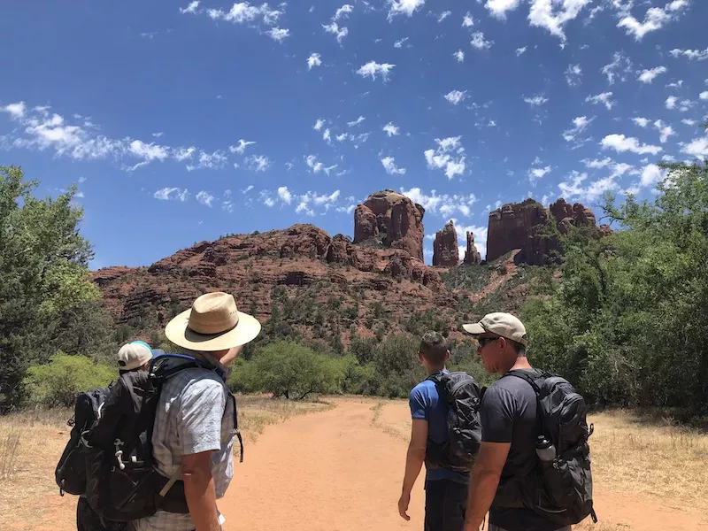 Male hikers looking at Cathedral Rock spires from Baldwin Trail trailhead.