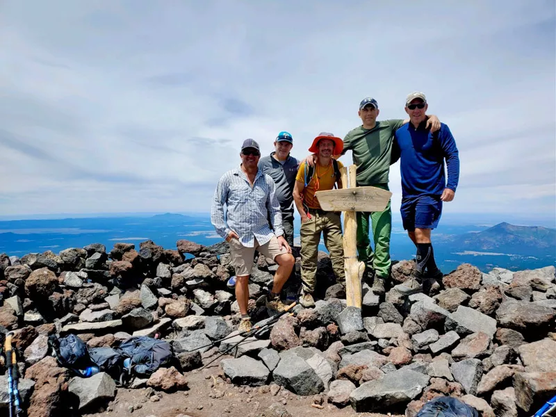 Hikers standing at Mount Humphreys Peak summit.