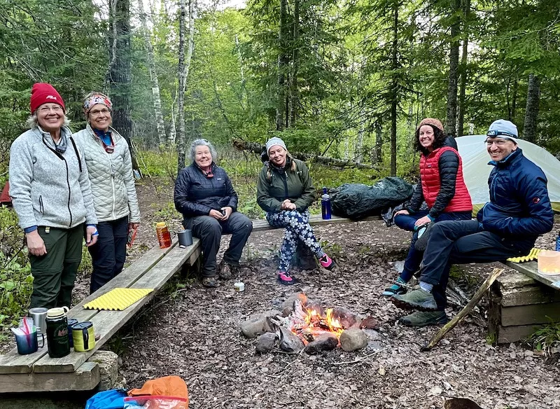 Hikers sitting around a warm campfire at Durfee Creek Campsite.