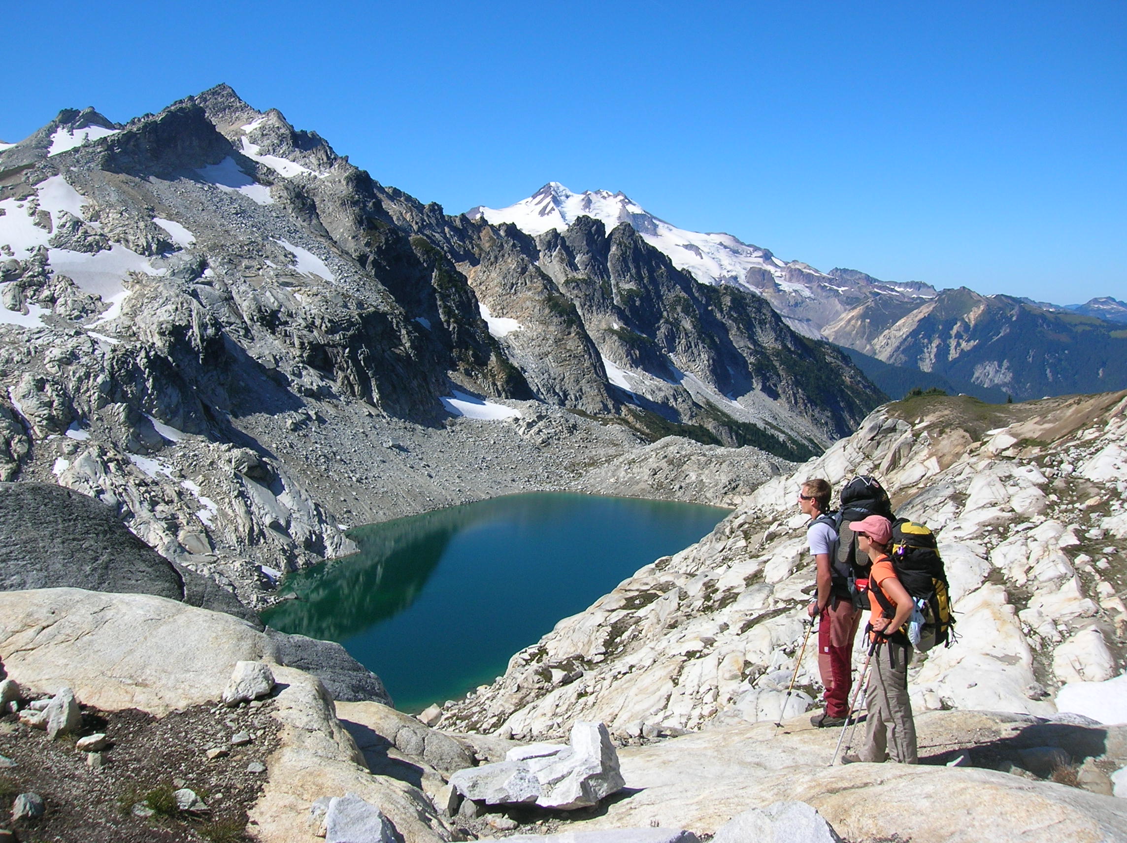 Hikers overlooking Triad Lake near High Pass in Glacier Peak Wilderness.